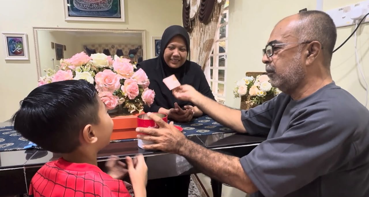 Seorang bapa menghulurkan hadiah kepada anak lelaki