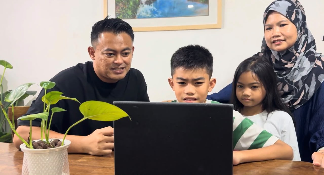 Bapa menemani dua anak di hadapan komputer riba